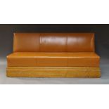 A brown upholstered three-seater sofa, 20th century, on oak rectangular plinth base.Provenance: