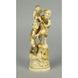 A Japanese okimono figure of a man holding a cooking pot and flask, with a boy at his feet, on an