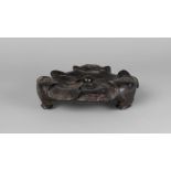 A Chinese hardwood tripod censer stand, 18th century, carved as lotus pads, with three ruyi-shaped
