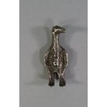 A white metal pendant or amulet, in the form of a standing bird figure, 5.5cm high
