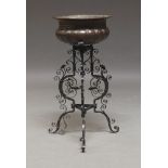 A copper jardiniere on worked wrought iron stand, late 19th, early 20th Century, 79cm high