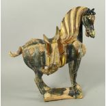 A Chinese terracotta caparisoned sancai glazed horse, in the Tang style, moulded with a flowing mane