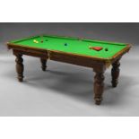 An oak snooker dining table, early 20th Century, with three leaves, raised on turned legs, 76.5cm