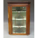 A mahogany flat fronted wall hanging corner cupboard, 19th century, with moulded cornice above