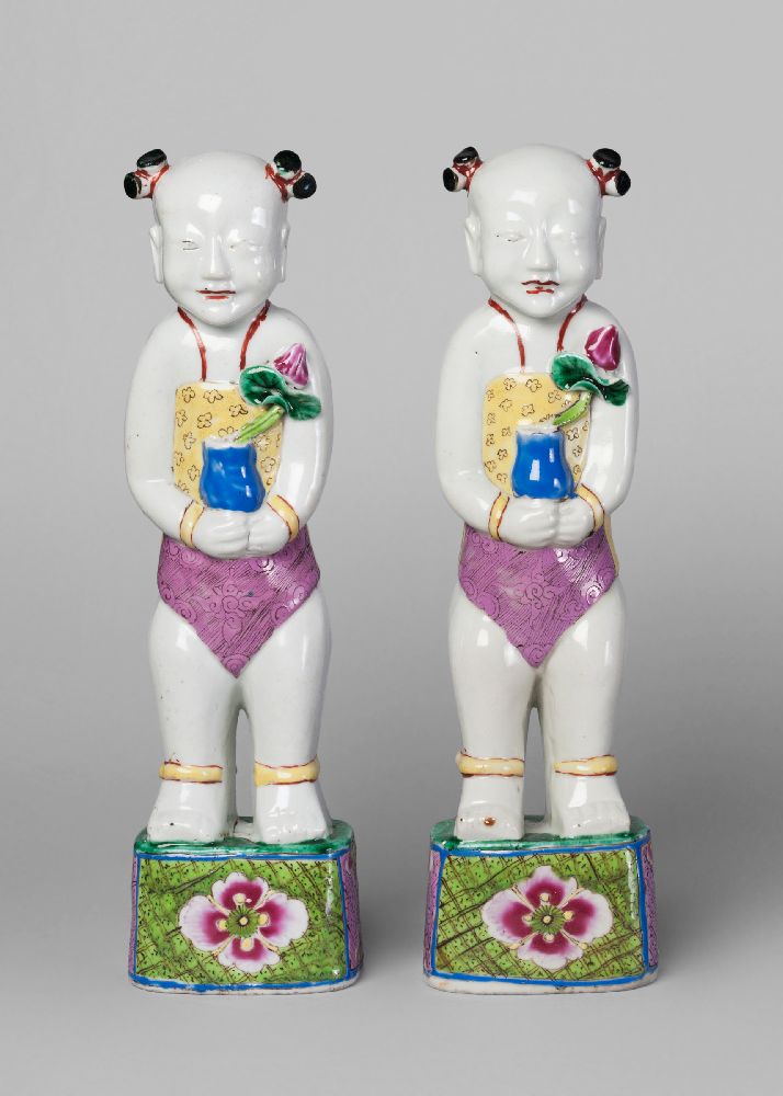 A pair of Chinese porcelain famille rose figures of boys, early 19th century, each modelled