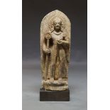 An Indian stone carving of a standing man, late19th/20th century, holding a staff in his hand