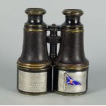 A pair of binoculars, 20th century, applied with two presentation plaques, one with a pennant with