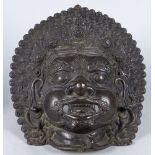 A large Sino-Tibetan style bronze mask of a god, 20th century, modelled with bulging eyes and a