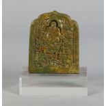 A green hard stone carving of a saint seated in meditation, surrounded by animals, within a shaped
