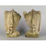 Two limestone urns, 19th century, modelled with classical draping over one handle, on square