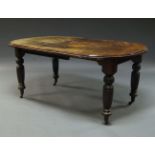 An Edwardian mahogany wind out dining table, with one additional leaf, on turned and reeded legs, on