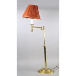 A brass floor standing lamp, late 20th century, with an extending arm, with a red pleated material