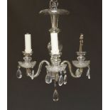 A three light glass chandelier, 20th century, with central bulbous column and chromed metal base,