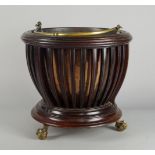 An Edwardian mahogany jardiniere, with circular ring top and slated body, on circular base with