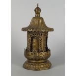 A Tibetan pressed metal table prayer wheel, late 19th/early 20th century, with a sloping roof, above