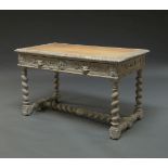 A Jacobean style limed oak writing table, early 20th Century, the rectangular top inset with tan
