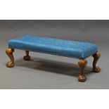 A George III style low stool, early 20th Century, upholstered in blue damask pattern fabric, with