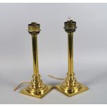 A pair of polished brass push form candlesticks, 19th century, converted to electric lamps, 40cm