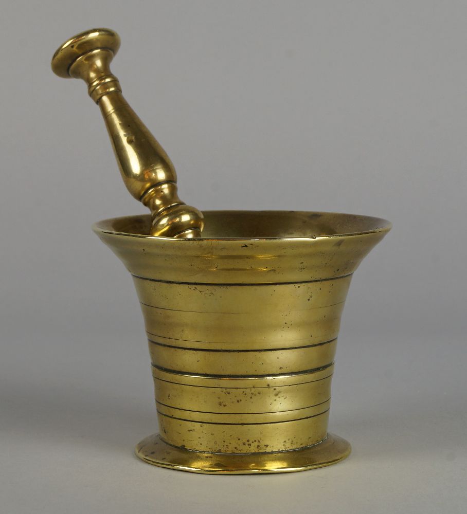 A polished bronze mortar and pestle, 18th century, the mortar 8.5cm high, the pestle 18.5cm (2)