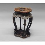 A Chinese black and red lacquer stand, late 19th/20th century, the top of shaped outline decorated