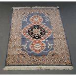 A pakistan bokhara rug with rows of guls in a blue field 176cm x 125cm and a rug with trilobe design