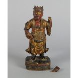 A Chinese painted and gilt lacquered God of Wealth, 18th/19th century, modelled wearing a gilt robe,