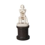 A French ivory model of Napoleon, 19th century, seated on a chair leaning on the back, with a