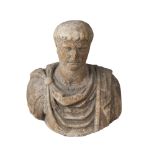A Grand Tour type stone bust of an Emperor, 18th/19th century, carved wearing a cloak over an
