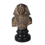 An Egyptian taste Grand Tour stone head fragment, 18/19th century, resting on a turned museum stand,
