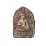 A Tibetan painted terracotta votive plaque, mid-19th century, of arched form, depicting Maitreya,