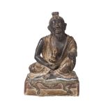 A Tibetan painted terracotta figure of Mahasiddha, early 19th century, depicted seated on a