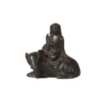 A Chinese bronze scroll weight, Ming dynasty, 17th century, modelled as Guanyin seated atop a