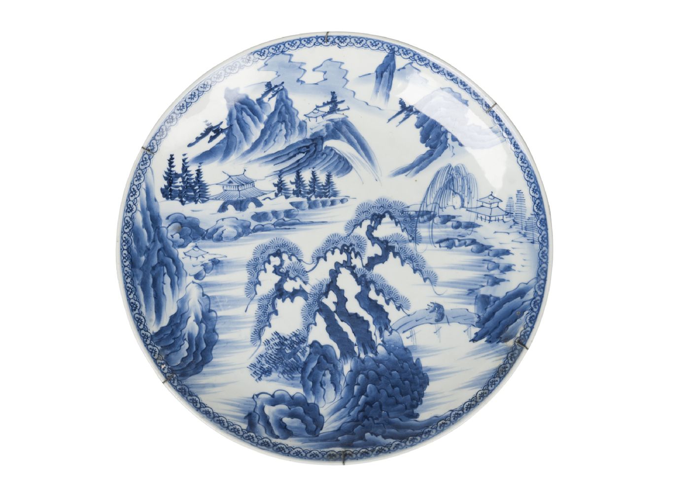 A large Japanese charger, early 20th century, painted in underglaze blue with a pine tree in an