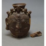 A large Nepalese terracotta jar, 20th century, formed as a Bhairava mask adorned with skulls, 58cm