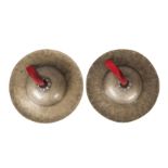 A pair of Tibetan beaten brass cymbals, 19th century, with repousse silver fittings, 31.5cm diameter