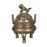 A Chinese polished bronze tripod censer, 19th century, with pierced cover decorated with lotus