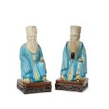 A pair of Chinese porcelain officials, 18th century, modelled seated, wearing turquoise robe,