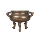 A Chinese bronze tripod censer, 18th/19th century, with archaistic handles, compressed body,