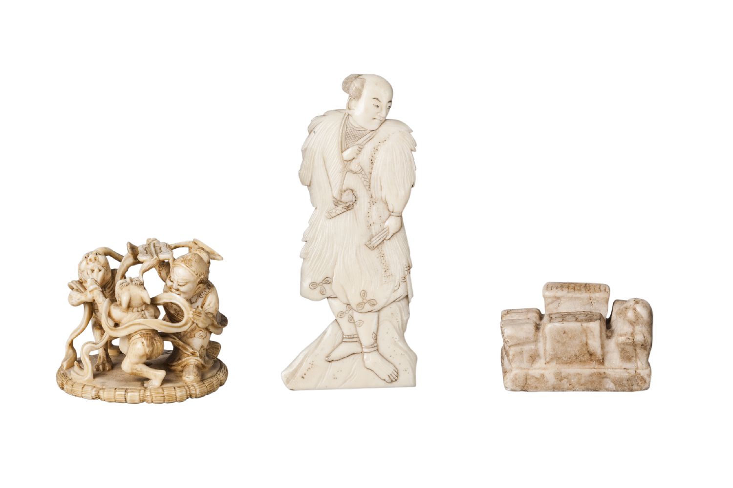 A Japanese ivory netsuke, late 19th century, carved as Shoki fighting two oni, signed to base, 4.5cm