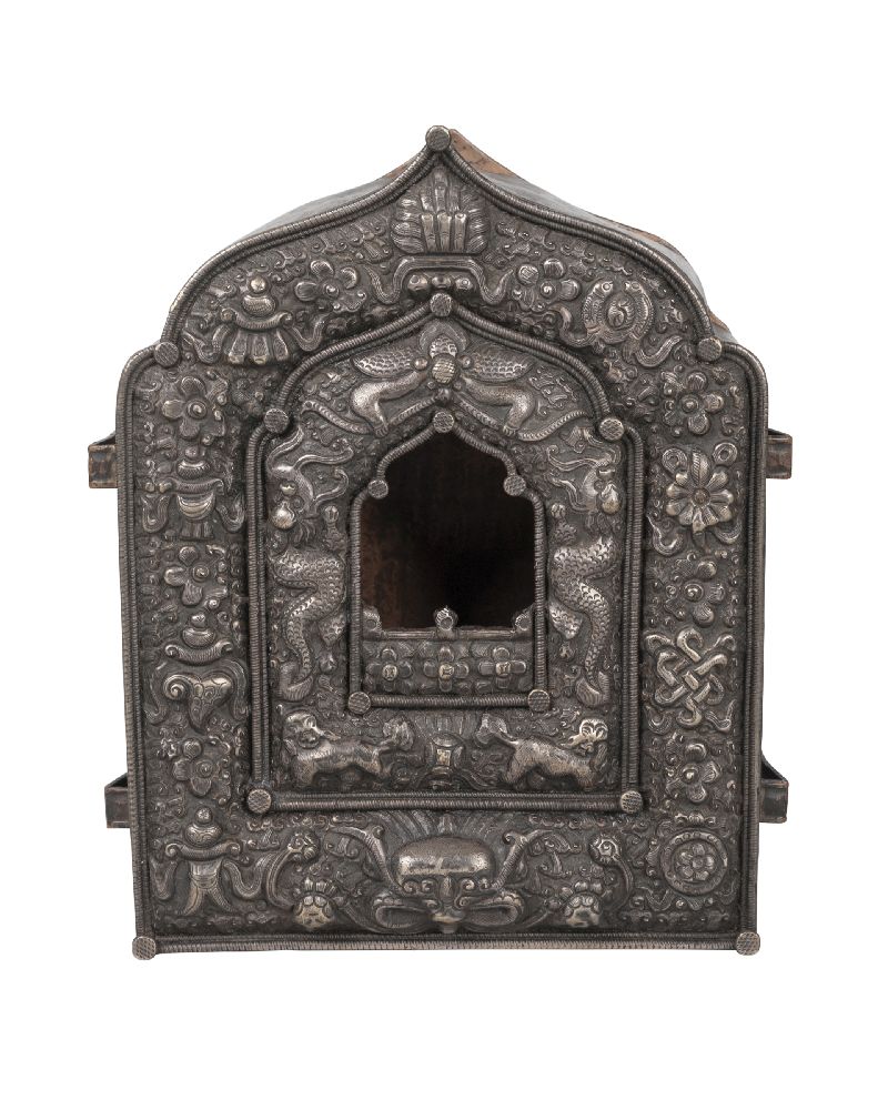 A Tibetan silver and copper backed gau, late 19th century, repousse decorated with Buddhist emblems,