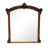 A Victorian mahogany over mantel mirror, of arched form, the top with centred vacant cartouche and