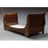 A French mahogany lit en bateau, late 19th Century, the scrolling ends with gilt metal rosettes,