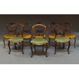 A set of five Victorian mahogany balloon back dining chairs with foliate and scroll work carved