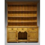 A Victorian pine dresser, the moulded cornice above open plate rack with three shelves, the base