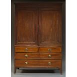 A George III mahogany and line strung linen press, the moulded cornice above two panelled doors,