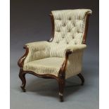 A Victorian mahogany button back armchair, upholstered in floral white and green stripe fabric, with