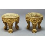 A pair of Italian carved gilt wood circular footstools, 19th Century, the tops upholstered in floral