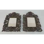 A pair of French bronzed metal wall mirrors, 20th century, each with pierced scrolling foliate