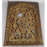 A Moroccan window grill, the central panel of pierced floral design, with a shaped frame applied