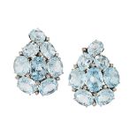 A pair of blue topaz and diamond ear clips, each designed as an oval mixed-cut pale blue topaz